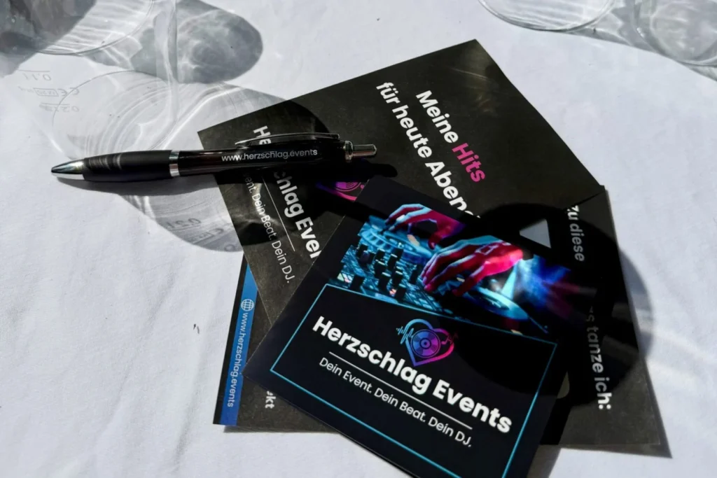 Musikwunschkarten und Visitenkarte von Herzschlag Events auf einem Hochzeitstisch