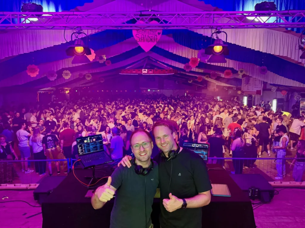 DJ-Duo vor der vollen Tanzfläche einer Zeltparty